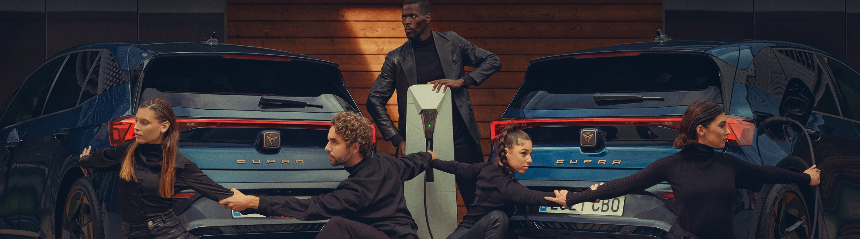 Two women charging the CUPRA Born Aurora Blue colour